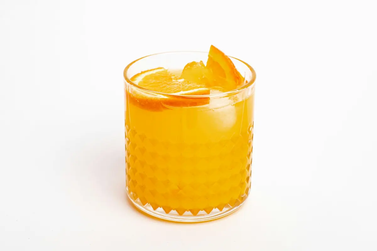 A glass of citrus juice with orange slices